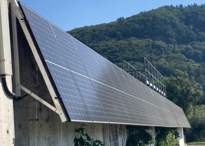 Auf dem Dach sind Solarpanels in Reihen angeordnet. Die glänzenden Oberflächen fangen das Sonnenlicht ein.